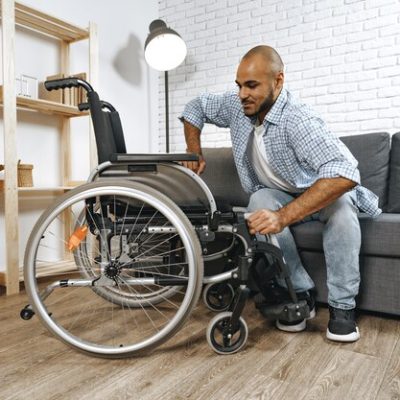 black-disabled-man-sits-down-wheelchair-home main